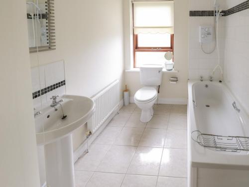 a bathroom with a tub and a toilet and a sink at Aisling in Foxford