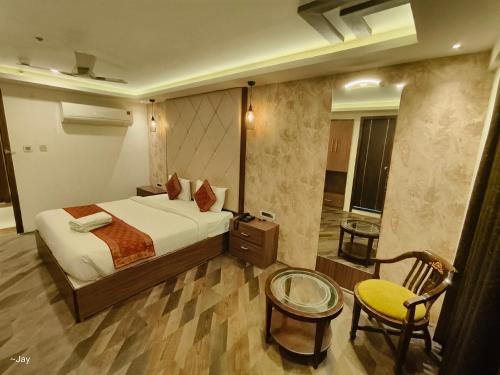 a bedroom with a bed and a table and a chair at Trimrooms Triumph Banaras Railway Station in Varanasi