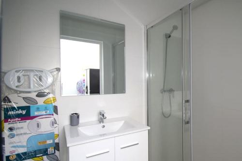 a white bathroom with a sink and a shower at Torrebeach in Torre de la Horadada