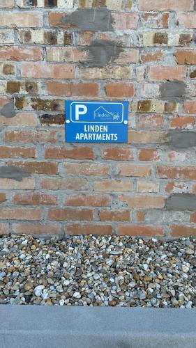 a sign on the side of a brick wall at Linden Apartman 106 - Adults Only in Mosonmagyaróvár