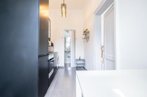 维也纳Inviting Economy 1BR Apt. with the best Location的厨房配有白色柜台和黑色冰箱。