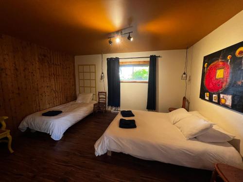 a room with two beds and a window at Chalet Epicea in Sainte-Anne-des-Monts