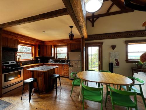 a kitchen with wooden cabinets and a table and chairs at Chalet Epicea in Sainte-Anne-des-Monts