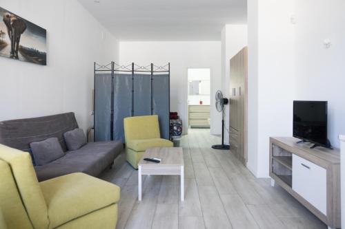 salon z kanapą i telewizorem w obiekcie MÁLAGA VELARDE cENTER w Maladze