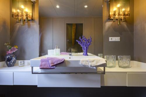 a bathroom with a sink with towels and a mirror at Pgrhome Luxury Apartments Maryloft in Cannareggio in Venice