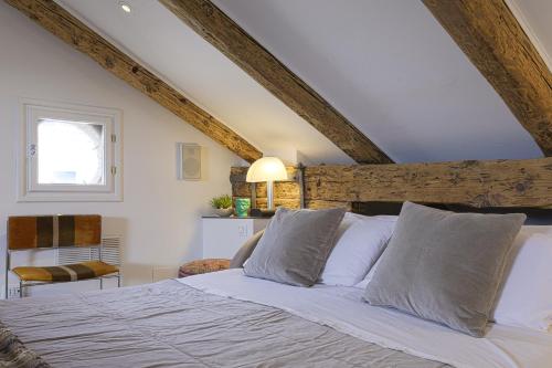 a bedroom with a bed with white sheets and a window at Pgrhome Luxury Apartments Maryloft in Cannareggio in Venice