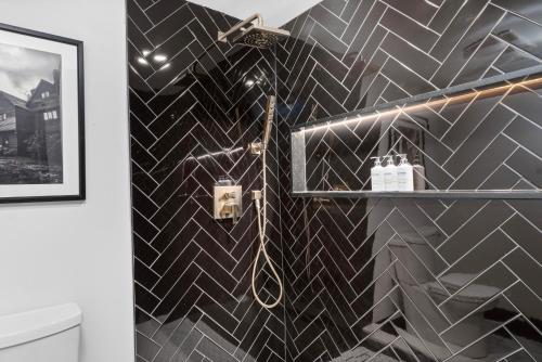 a bathroom with a black and white tiled wall at The Cove At Salem in Salem