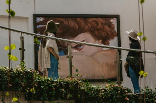 two people standing in front of a painting of a woman at Hacienda del Valle Sagrado in Urubamba