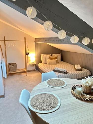 een kamer met een tafel en stoelen en een bed bij Studio Calme et Cosy -Gare- in Bourg-en-Bresse