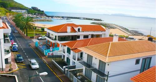 een luchtzicht op een straat met huizen en de oceaan bij V.I.P. Baia in Machico