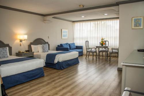 a hotel room with two beds and a table at Hotel Santander Plaza in Guatemala