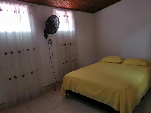 a bedroom with a bed and a fan on the wall at Casa lowcost relajación total! in La Dorada