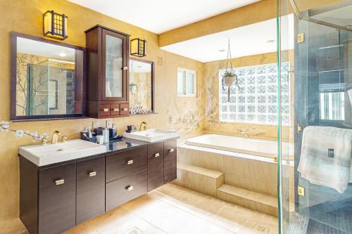 een badkamer met 2 wastafels, een bad en een douche bij A Little Piece of History in Boston
