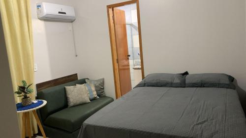 um quarto com uma cama e um sofá verde em Thermas do Bandeirante em Caldas Novas