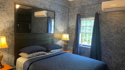 a bedroom with a bed and a mirror and a window at Belize Budget Suites in San Pedro