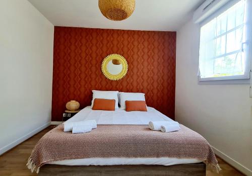 een slaapkamer met een groot bed met een rode muur bij Happy Stay Disney Two - Apartment with garden & parking in Montévrain