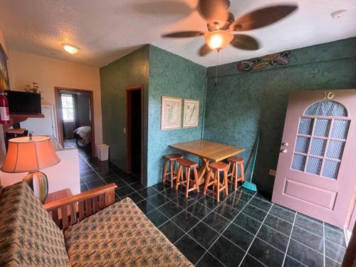 a living room with a table and chairs and a ceiling fan at Belize Budget Suites in San Pedro