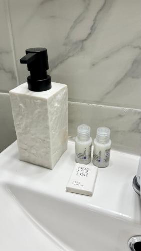 un comptoir de salle de bains avec un distributeur de savon et des médicaments dans l'établissement Le Bussy - Chambre double Disney, à Bussy-Saint-Georges