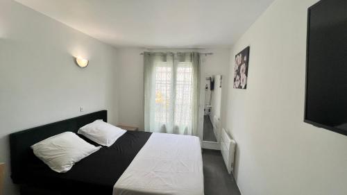 une chambre avec un lit noir et blanc et une fenêtre dans l'établissement Le Bussy - Chambre double Disney, à Bussy-Saint-Georges