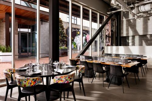 a restaurant with tables and chairs and windows at JW Marriott Savannah Plant Riverside District in Savannah