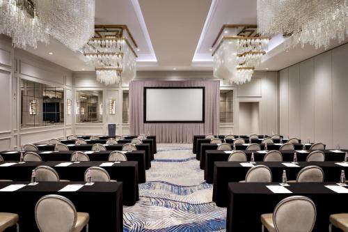 a large room with tables and chairs and a screen at JW Marriott Savannah Plant Riverside District in Savannah