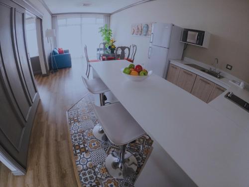 a kitchen with a counter with a bowl of fruit on it at Hotel Santander Plaza in Guatemala