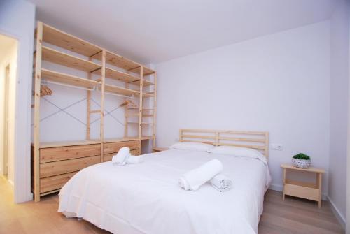 een slaapkamer met een groot wit bed met witte lakens bij Santa Maria apartment in Vilassar de Mar