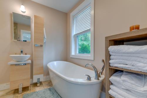La salle de bains est pourvue d'une baignoire, d'un lavabo et de serviettes. dans l'établissement Secluded Upstate NY Forest Cottage on 33 and Acres!, à Oneonta