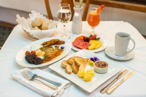 a table with plates of breakfast food and glasses of wine at Hotel Santander Plaza in Guatemala
