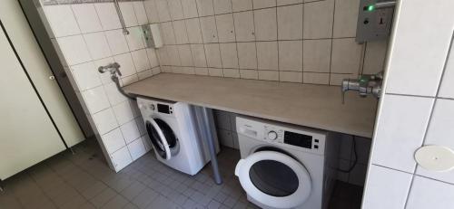 a bathroom with a washer and a washing machine at Rosental Apartments Self Check-in in Ferlach