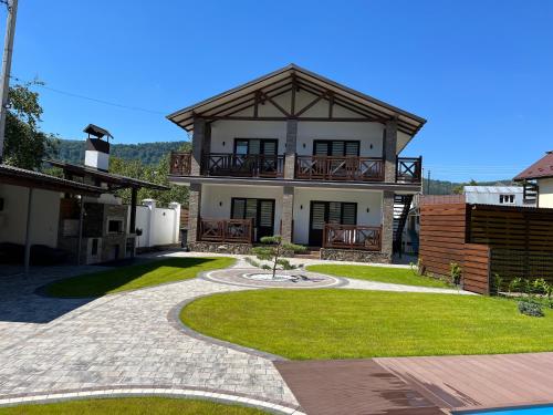 a large house with a balcony and a yard at Гірський Кришталь in Skole