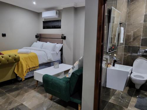 a bedroom with a bed and a bathroom with a sink at @ 21 Guest House in Pietermaritzburg
