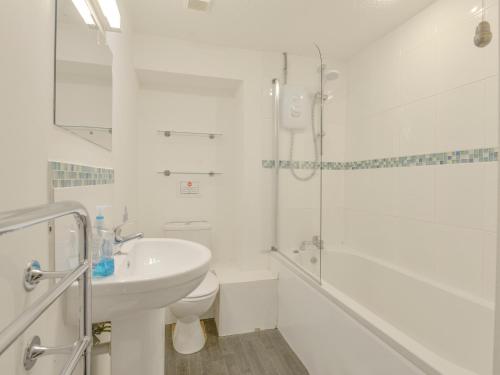 a bathroom with a sink and a toilet and a shower at Primrose Cottage in Wadebridge