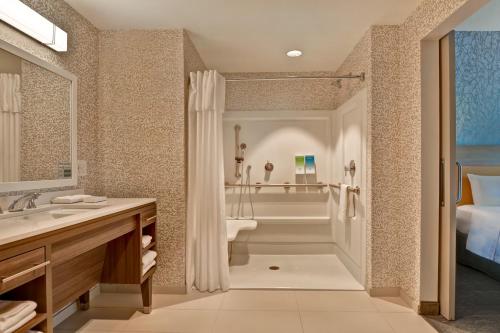 a bathroom with a tub and a sink and a shower at Home2 Suites By Hilton Naples I-75 Pine Ridge Road in Naples