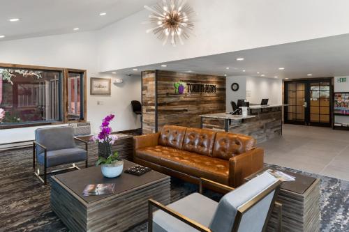 a lobby with a leather couch and tables and chairs at Torian Plum Creekside II in Steamboat Springs