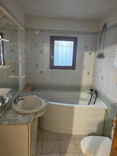 y baño con bañera, lavabo y aseo. en Casita, en Le Blanc-Mesnil