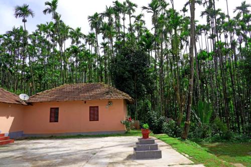 a house with a fire hydrant in front of a yard at Badamane Jungle Stay - Jeep Ride & Mountain View in Chikmagalūr