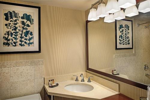 La salle de bains est pourvue d'un lavabo et d'un miroir. dans l'établissement Sheraton Westport Lakeside Chalet, à Maryland Heights