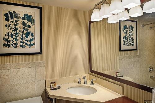 a bathroom with a sink and a mirror at Sheraton Westport Lakeside Chalet in Maryland Heights