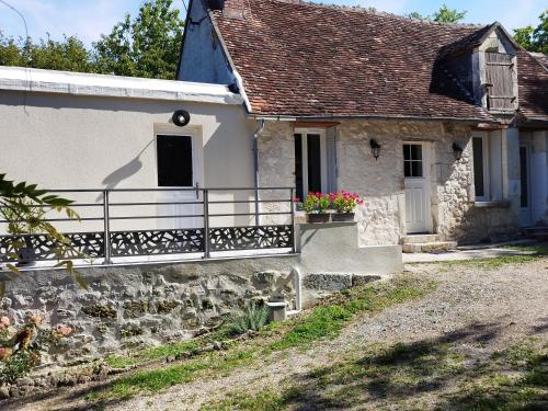 an old stone house with a balcony and flowers at Les Ecureuils 4 / 6 personnes in Seigy