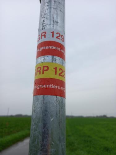 a pole with stickers on it on a street at Camping des Saules in Jurbise