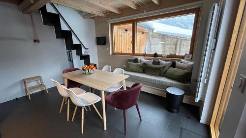 - une chambre avec une table, des chaises et un canapé dans l'établissement Chalet*** au pied d'une prairie face à la montagne, à Sixt-Fer-à-Cheval