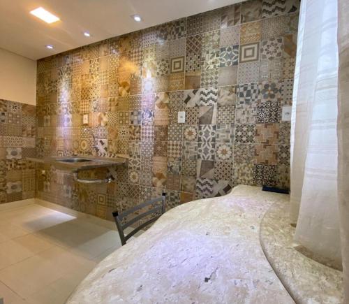 a bedroom with a bed and a tiled wall at Pousada Dubai in Itabuna