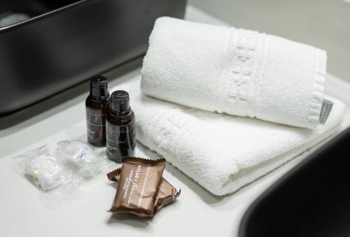 a bathroom counter with a towel and two bottles of soap at Pousada Suiça Mineira Centro in Monte Verde