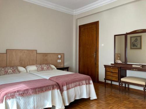 a bedroom with a bed and a dresser and a mirror at Las Mañanitas in Tafalla