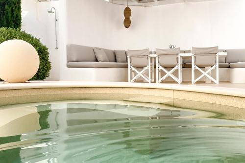 a pool in a living room with chairs and a couch at VILLA EKAVI NAOUSA - at the hub of Naousa village in Naousa