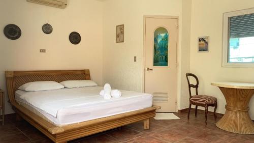 - une chambre avec un lit avec des draps blancs et une table dans l'établissement Sunset Beach Resort, à Moalboal