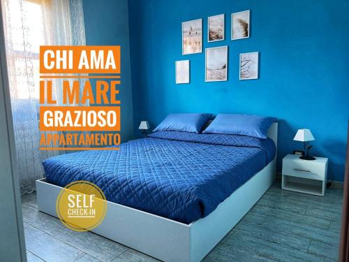 a bedroom with a bed with a blue wall at [Chi Ama il Mare] Appartamento in Latina