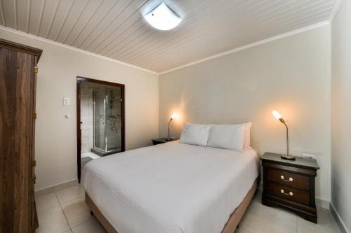 a bedroom with a large white bed with a night stand at NEW Apartment Ocean View with Amazing Sunsets in Sabana Berde