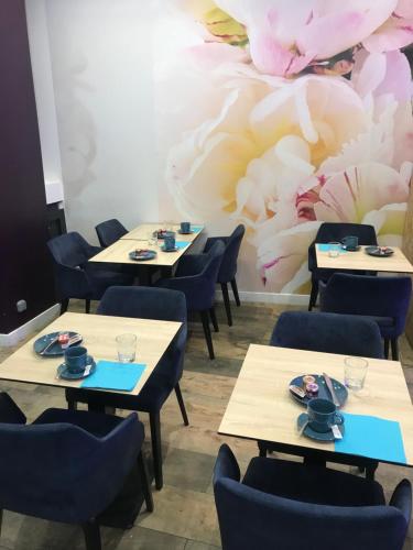 une salle à manger avec des tables et des chaises ainsi qu'une fresque murale. dans l'établissement Hôtel Flor Rivoli, à Paris